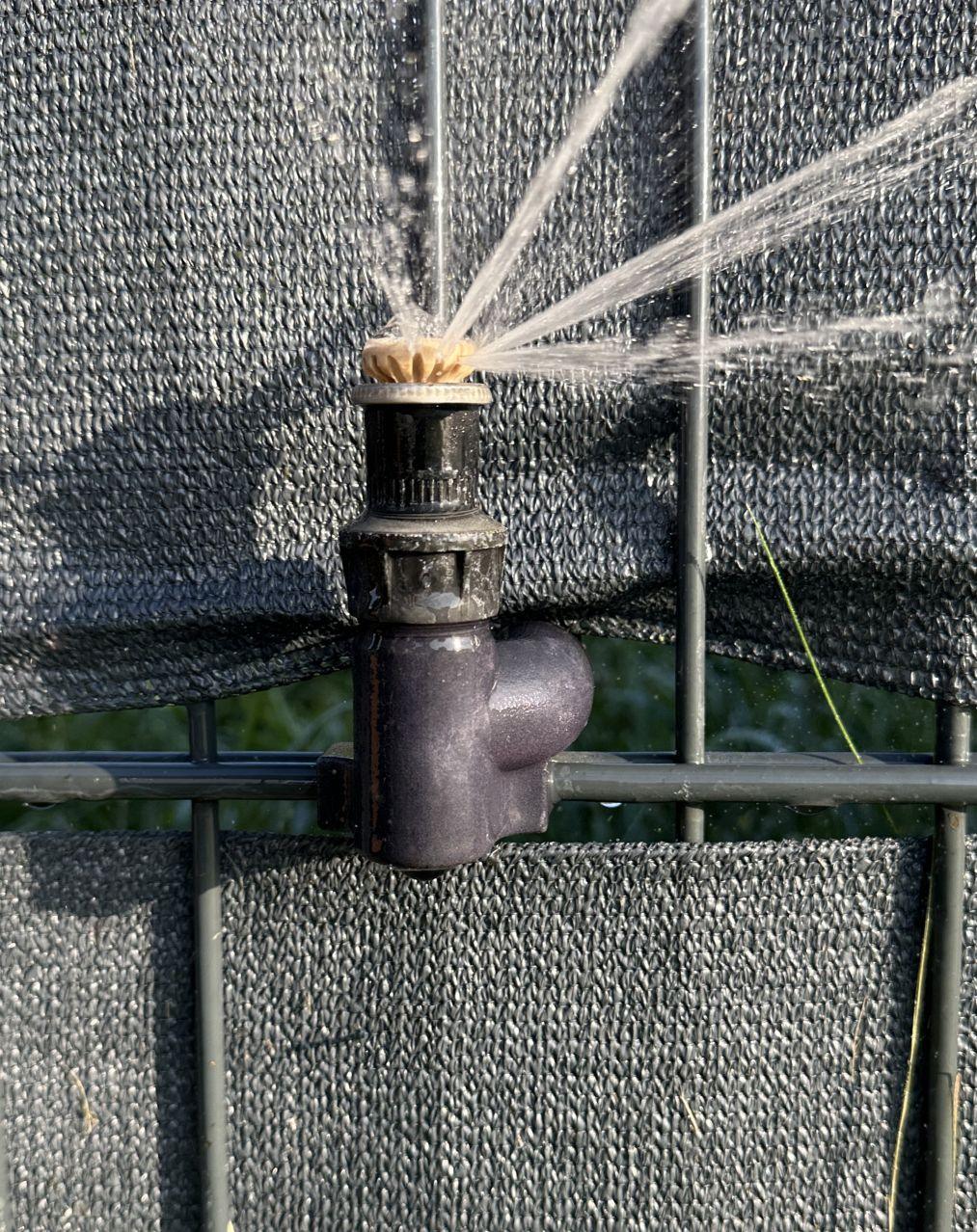 Anwendungsbeispiel für einen Gartenschlauch-Adapter, der einen Sprinkler an einem Zaun feixieren kann